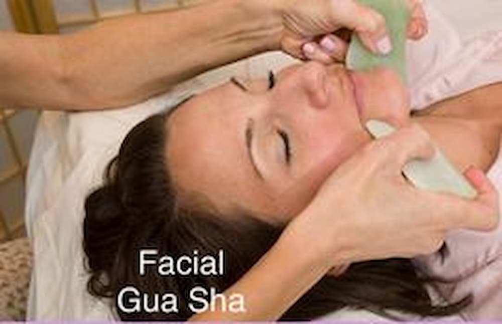 A woman getting her face waxed at the spa.
